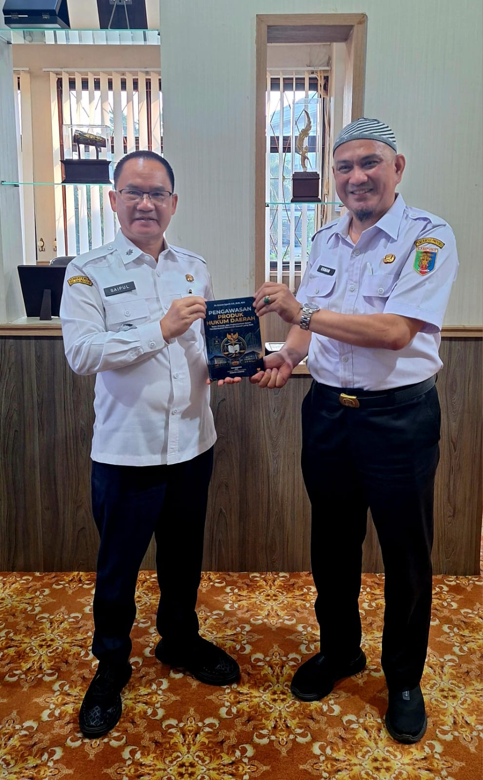 Dr. Erman Syarif Serahkan Buku “Pengawasan Produk Hukum Daerah” kepada Kepala Bapenda Lampung